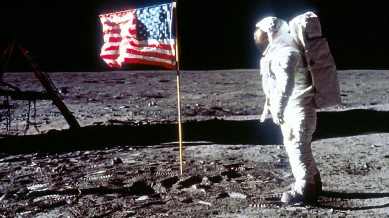 _107563830_buzz-aldrin-poses-next-to-flag